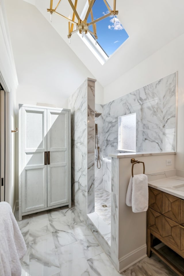 bathroom featuring a tile shower, vaulted ceiling with skylight, vanity, and a chandelier