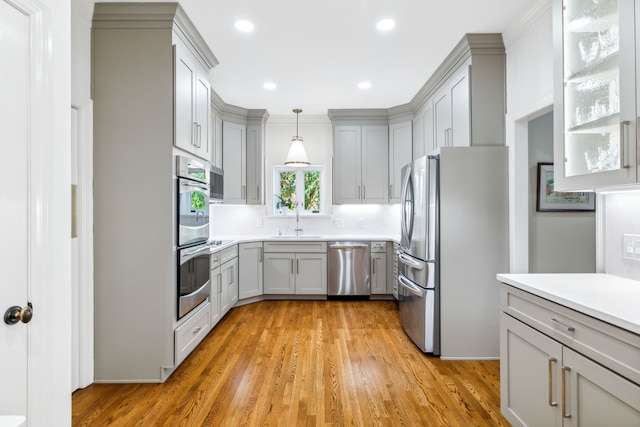 kitchen featuring gray cabinets, light wood-type flooring, sink, and appliances with stainless steel finishes