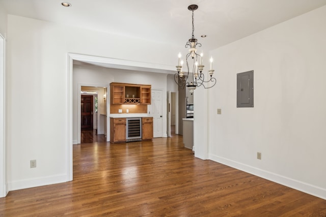 unfurnished dining area featuring electric panel, beverage cooler, a notable chandelier, and dark hardwood / wood-style floors