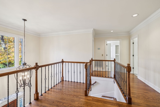 hall featuring crown molding, dark wood-type flooring, and a notable chandelier