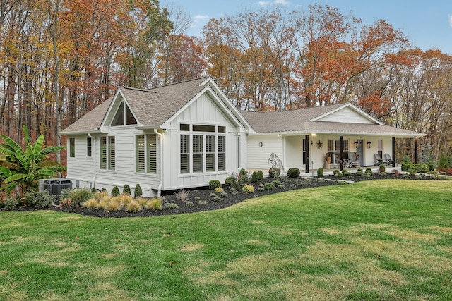 exterior space featuring a porch, a yard, and cooling unit