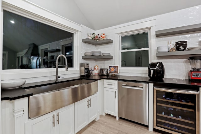 kitchen with decorative backsplash, stainless steel dishwasher, beverage cooler, light hardwood / wood-style floors, and white cabinetry