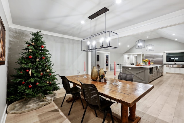 dining room with vaulted ceiling and light hardwood / wood-style flooring