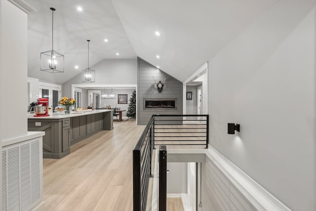 interior space featuring a fireplace, wood-type flooring, and vaulted ceiling