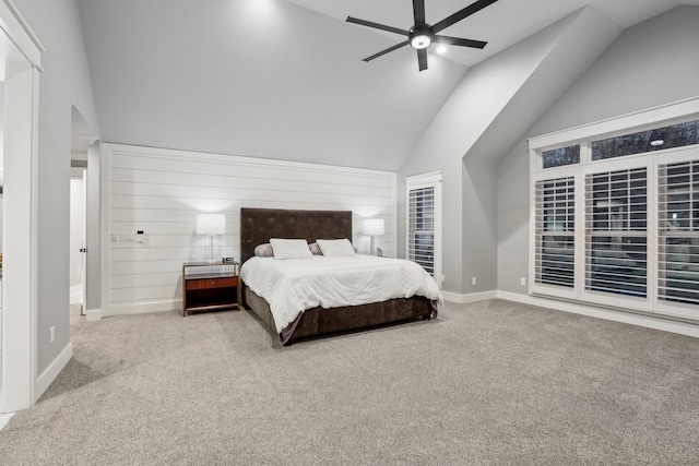 bedroom featuring carpet flooring, ceiling fan, wood walls, and vaulted ceiling