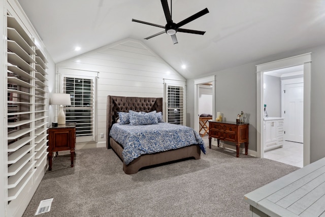 bedroom featuring ensuite bath, ceiling fan, light carpet, and lofted ceiling