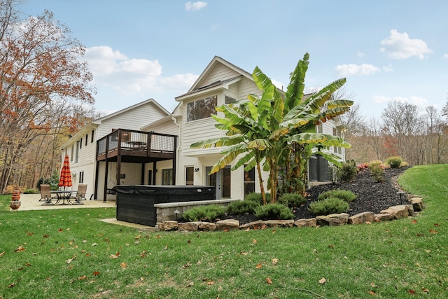 back of property with a yard, a patio, a hot tub, and a wooden deck