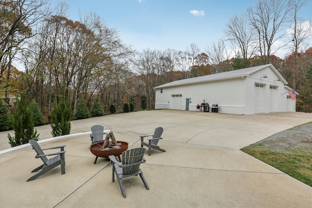 exterior space featuring a fire pit, a garage, and an outbuilding