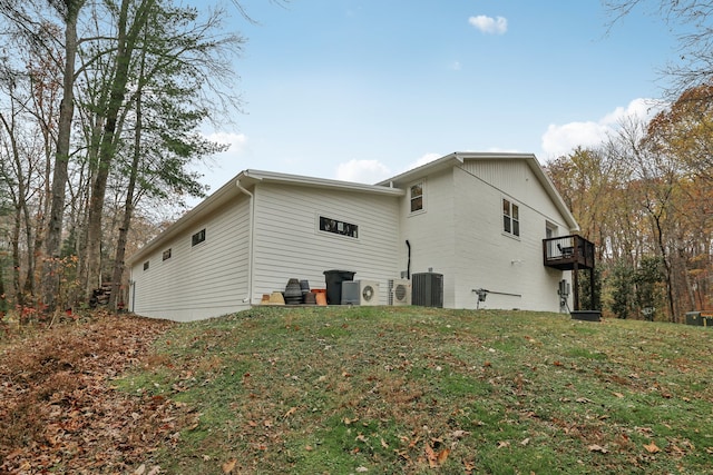 view of side of home featuring a yard and central AC