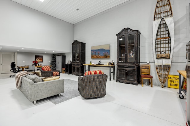 living room with a high ceiling and concrete floors