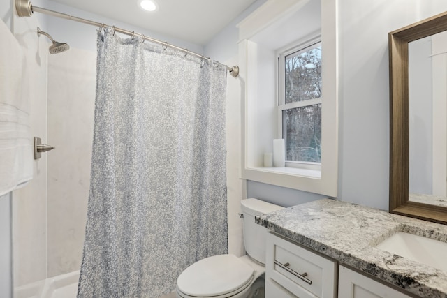 bathroom with a shower with shower curtain, vanity, and toilet