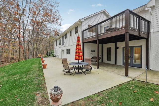 back of property with a lawn, a deck, a patio, and french doors