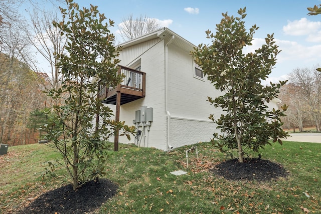 view of home's exterior with a yard and a balcony