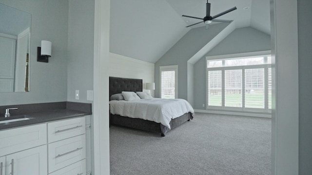 carpeted bedroom with ceiling fan, lofted ceiling, and sink