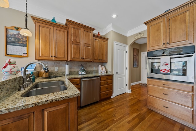 kitchen with appliances with stainless steel finishes, dark hardwood / wood-style flooring, tasteful backsplash, sink, and hanging light fixtures