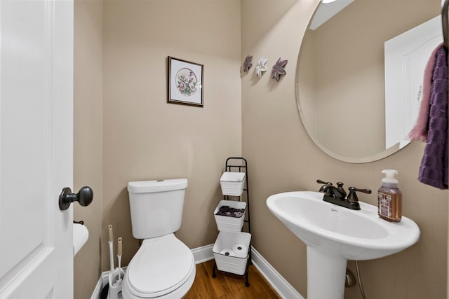 bathroom featuring sink, wood-type flooring, and toilet