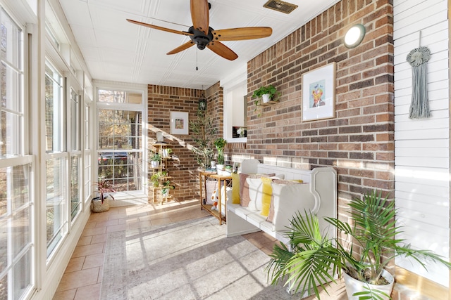 unfurnished sunroom featuring ceiling fan