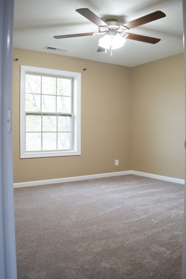 spare room featuring carpet and ceiling fan