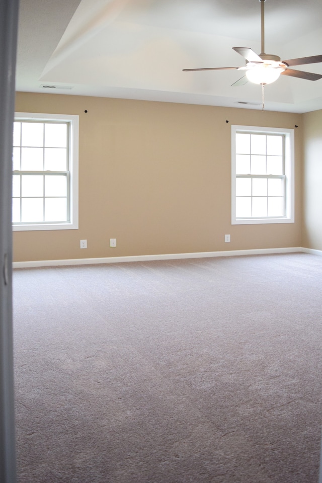 carpeted empty room featuring ceiling fan and plenty of natural light