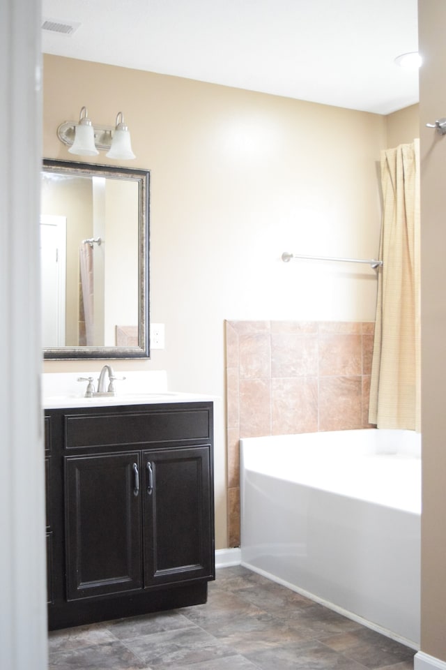 bathroom with a washtub and vanity