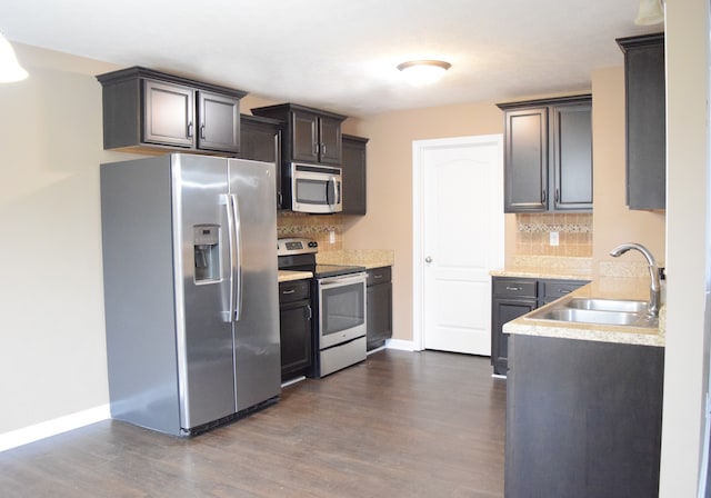 kitchen with tasteful backsplash, sink, stainless steel appliances, and dark hardwood / wood-style floors