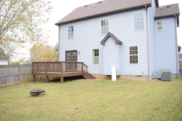 back of property with a lawn, cooling unit, an outdoor fire pit, and a wooden deck