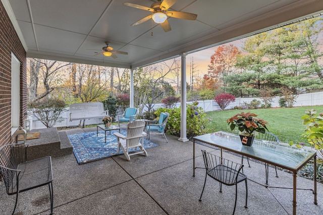 patio terrace at dusk with ceiling fan and a lawn