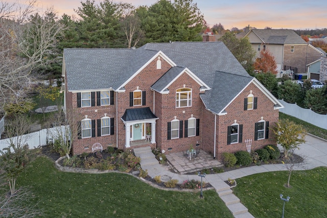 front of property with a patio and a lawn