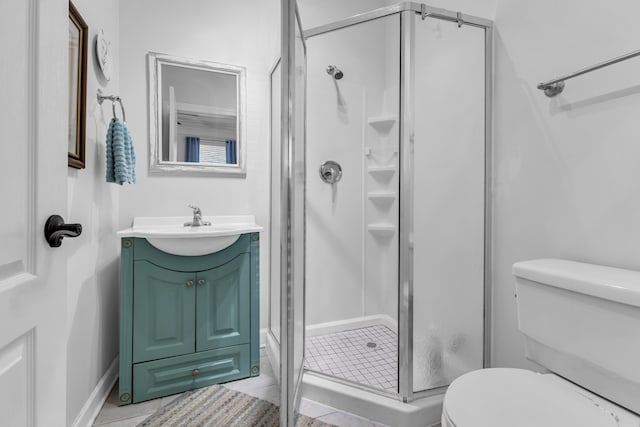 bathroom with tile patterned flooring, vanity, toilet, and a shower with shower door