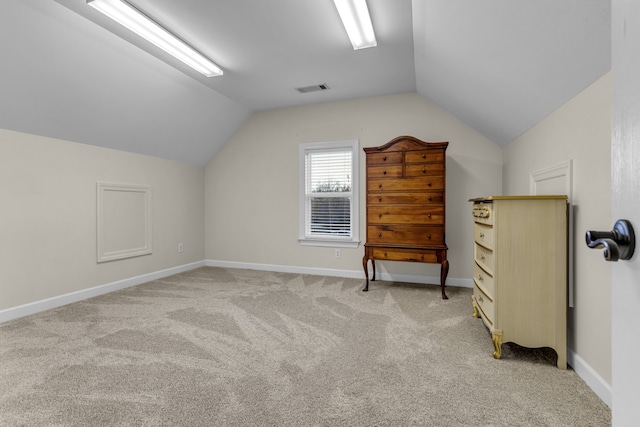 additional living space featuring light carpet and lofted ceiling