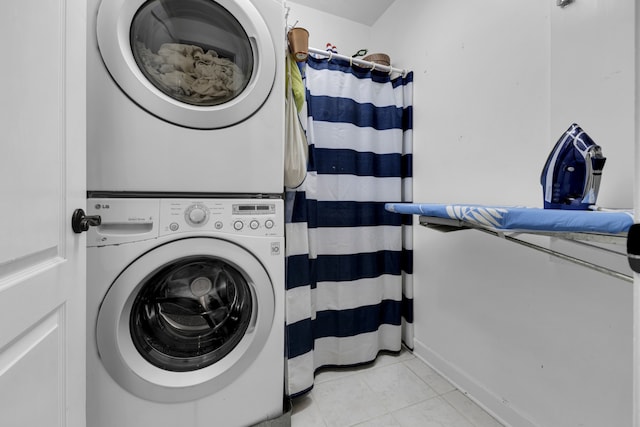 washroom featuring light tile patterned flooring and stacked washing maching and dryer