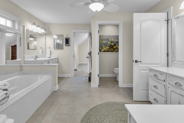 bathroom with vanity, tile patterned floors, a bathing tub, ceiling fan, and toilet