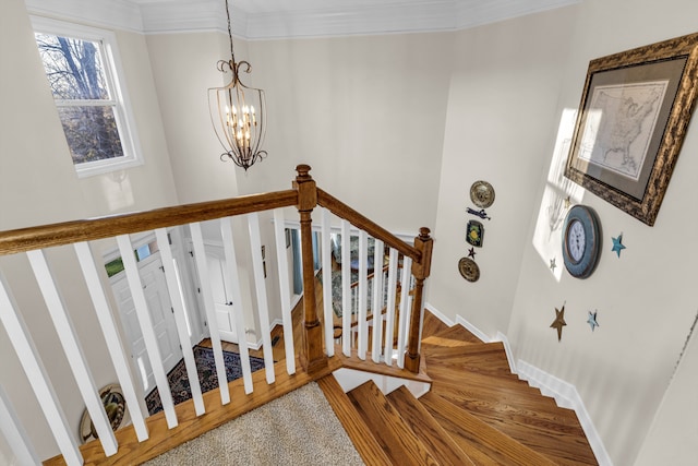 staircase featuring wood-type flooring and a chandelier