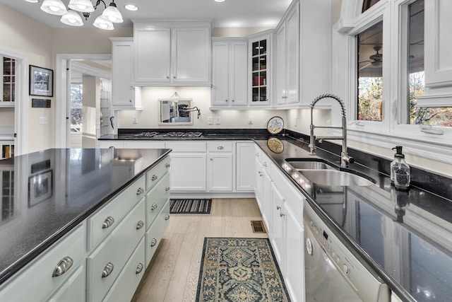 kitchen with sink, hanging light fixtures, light hardwood / wood-style flooring, white cabinetry, and stainless steel appliances