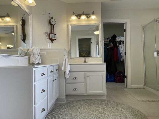 bathroom with ceiling fan, tile patterned flooring, vanity, and a shower with shower door