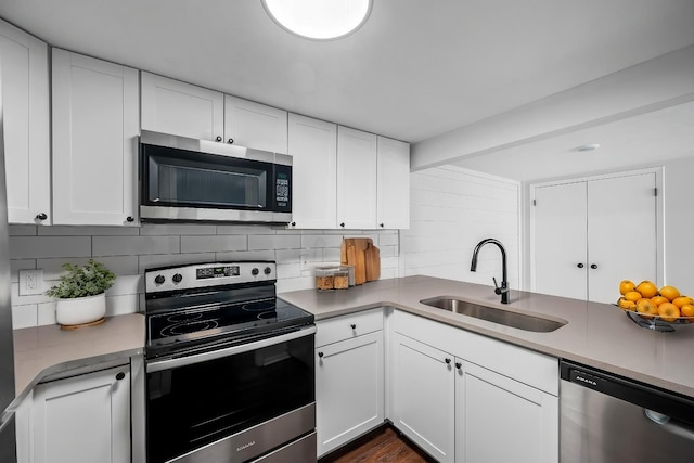 kitchen featuring appliances with stainless steel finishes, sink, decorative backsplash, and white cabinets