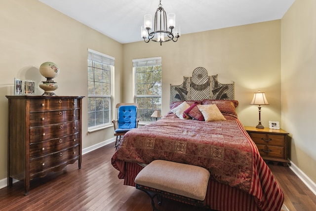 bedroom with a chandelier and dark hardwood / wood-style floors