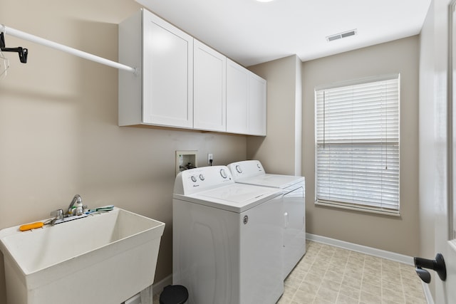 laundry room with washer and dryer, cabinets, and sink