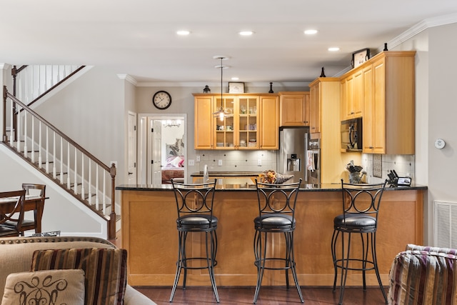 kitchen with stainless steel fridge with ice dispenser, kitchen peninsula, a kitchen bar, decorative backsplash, and ornamental molding