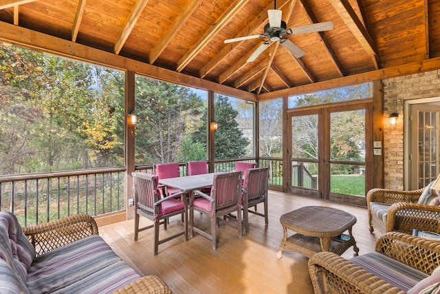 sunroom with lofted ceiling with beams, ceiling fan, and wooden ceiling