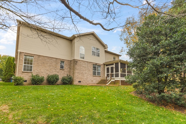 rear view of property with a lawn and a sunroom