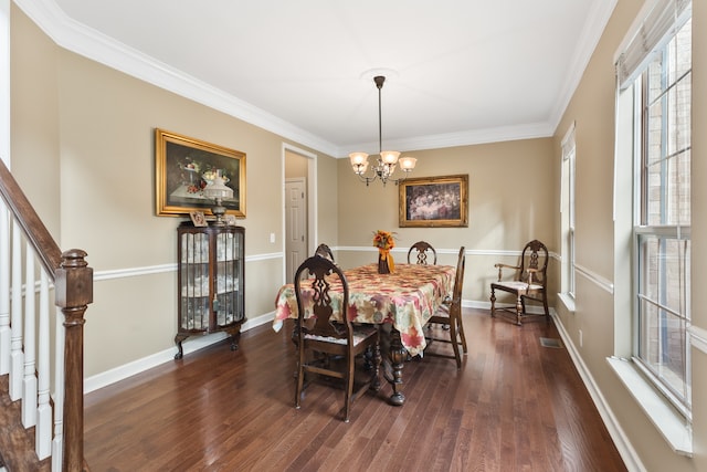 dining area with a notable chandelier, dark hardwood / wood-style flooring, and crown molding