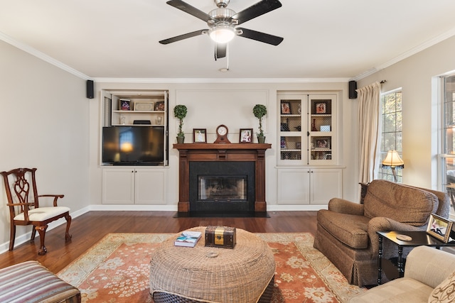 living room with ornamental molding, ceiling fan, and dark wood-type flooring