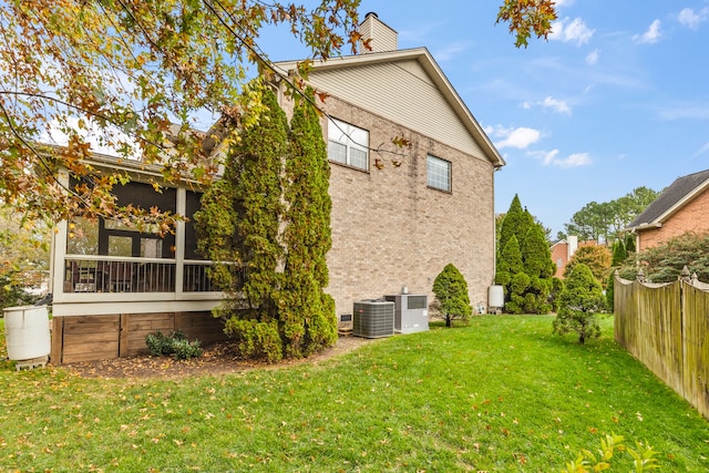 back of property with a yard and central air condition unit