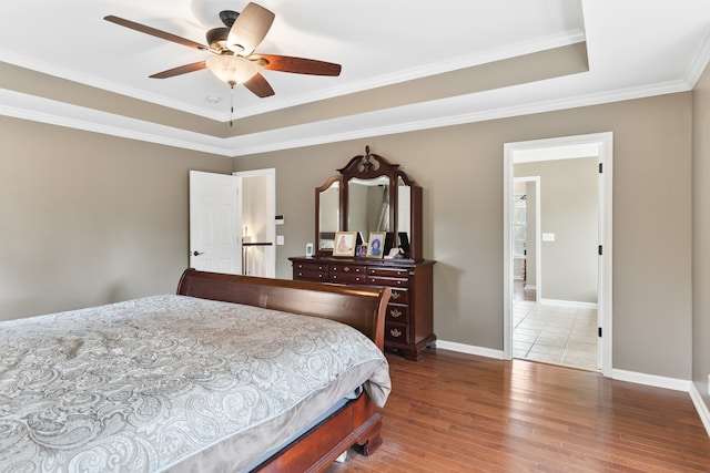 bedroom with ceiling fan, crown molding, and wood-type flooring