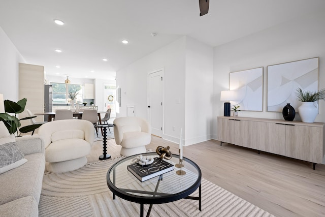 living room with ceiling fan and light hardwood / wood-style floors