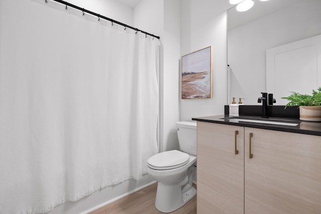 full bathroom featuring shower / tub combo, vanity, hardwood / wood-style flooring, and toilet