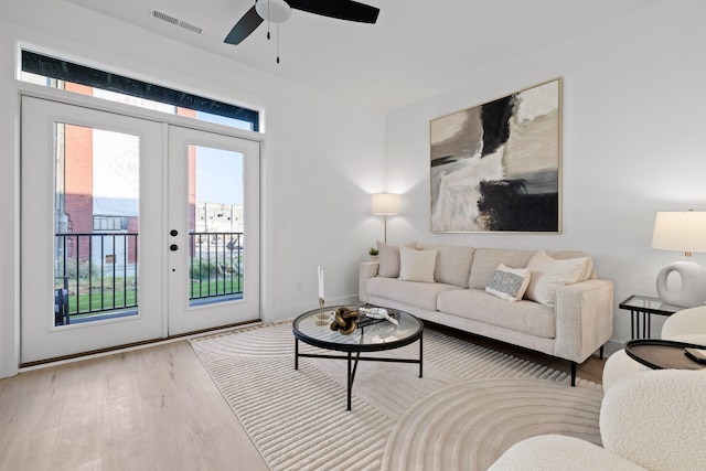 living room featuring ceiling fan, french doors, and light wood-type flooring