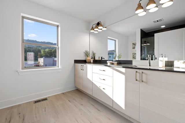 bathroom with wood-type flooring, vanity, and walk in shower