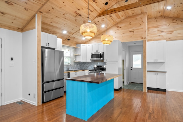 kitchen featuring dark hardwood / wood-style flooring, stainless steel appliances, pendant lighting, wooden ceiling, and white cabinetry